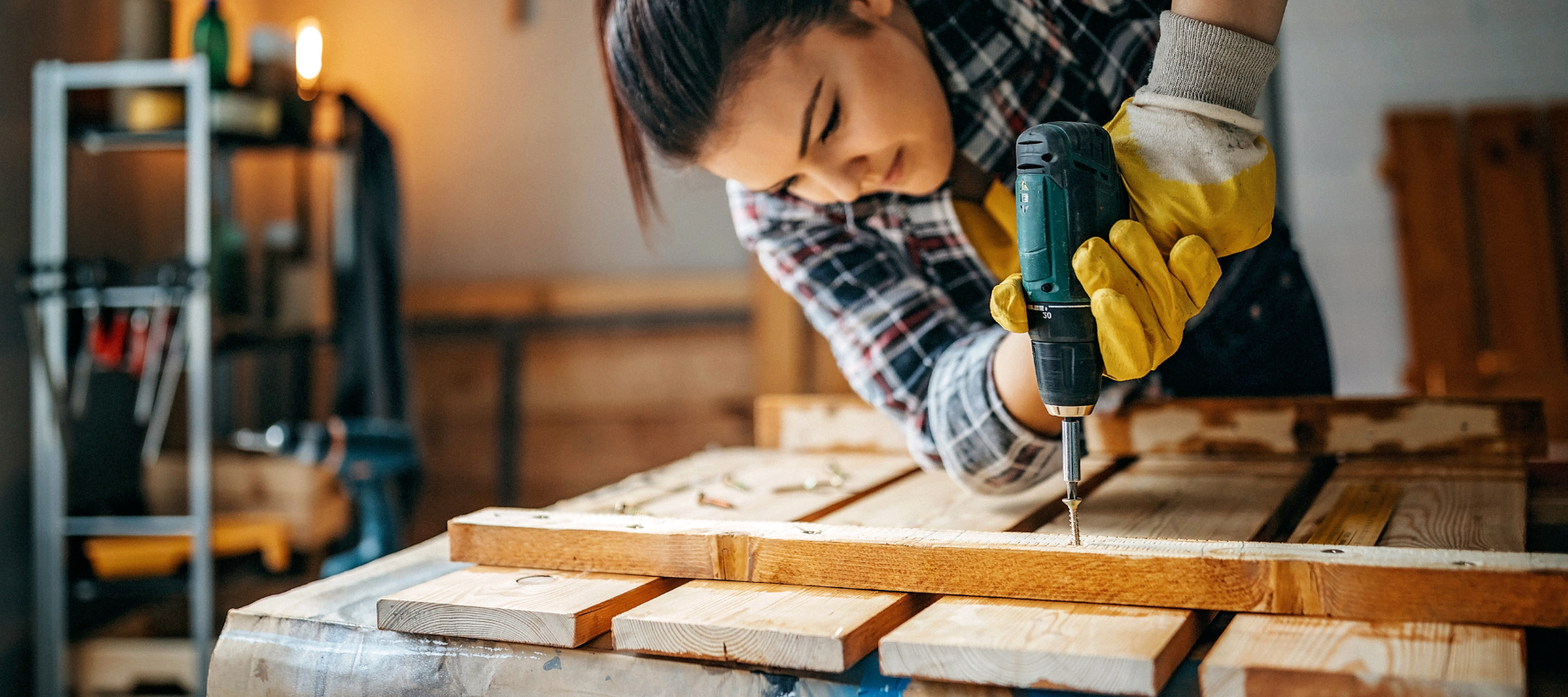 A power drill being used to draw a wood screw into a project.